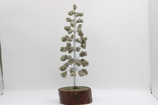 Decorative metal tree sculpture on a wooden base against a white background